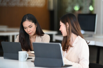 Two Successful businesswomen are discussing business plan in modern office.