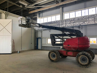 Man lift vehicle inside industrial building. Man lifting platform machinery