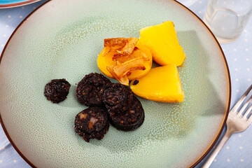 Blood sausage black pudding served with boiled potato and fried onion