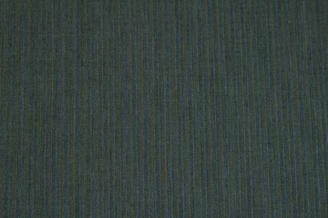 Textured background of wool fabric in a small stripe of blue-green colors for warm winter clothing. Horizontal orientation