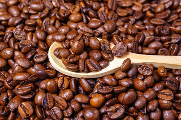 coffee beans close-up pours a wooden spoon. selective focus