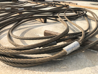 Coiled steel cables of lifting machinery. Crane parts at outdoor warehouse
