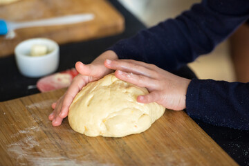 Little hand of baby mixing flour in the kitchen