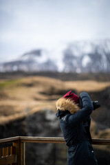 A photographer taking photos of a mountain landscape in Iceland 