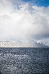 Fototapeta na wymiar Landscape of snowy mountains and sea in Iceland on a cloudy day