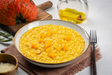 Pumpkin risotto on white table. Close-up. Ingredients on background.