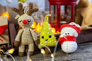 Deer, snowman and amigurumi herringbone on a wooden background. The concept of a cozy, magical Christmas and New Year.