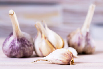 Fresh ripe garlic cloves and bulbs on a wooden table. Healthy organic food, vitamins, organic food, natural background