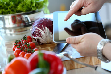 Man Vlogger Pointing Vegan Vegetables Salad Recipe. Chef Recording Red Tomato and Cabbage. Vlog for Organic Nutrition Concept. Chef Cooking Vegetarian Food in Kitchen at Home Horizontal Photography