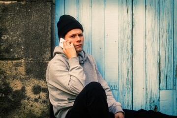 Obraz premium disappointed and sad man talking with mobile or cell phone