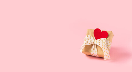 Gift or present box with red heart on pink background. Pastel colors, copy space for text and design. Valentine gift. Banner for Christmas, hew year, birthday concept.