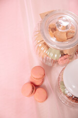 two glass containers with macarons on pink tulle