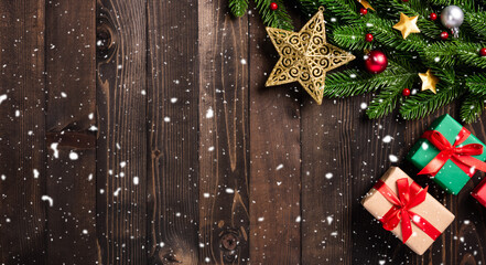 Christmas holiday garland border, Top view flat lay tree fir branches, and Xmas ornament bauble decor, the stars and gift box on black table wood background with copy space, Happy new year day concept