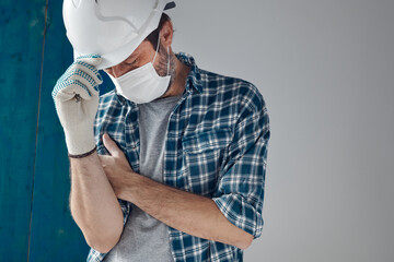 Worried construction engineer with protective face mask