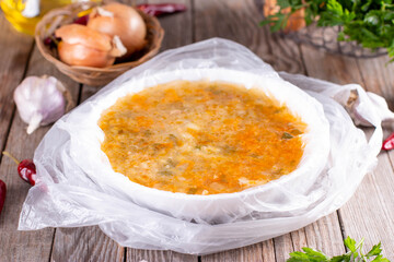 Frozen soup in a bowl on a wooden background. Frozen food