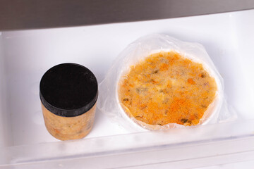 Soup in a container in the freezer. Frozen food