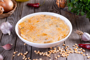 Frozen soup in a bowl on a wooden background. Frozen food
