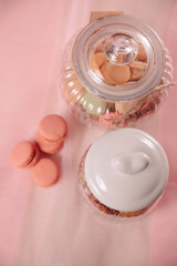 two glass containers with macarons on pink tulle