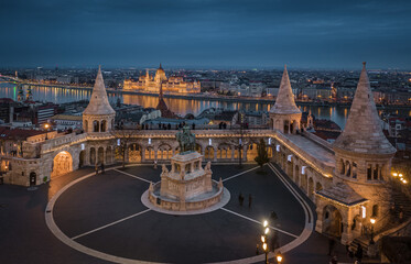 Budapest, Hungary - Aerial ciew of the famous Fisherman's Bastion at dusk with Christmas festive lights, statue of King Stephen I and Parliament of Hungary at background on a winter afternoon