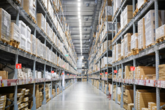 Huge distribution warehouse with high shelves and loaders. Blur background.