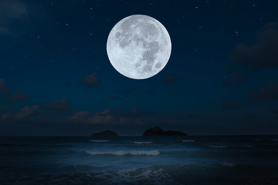 Full moon over sea in the dark night. © Onkamon