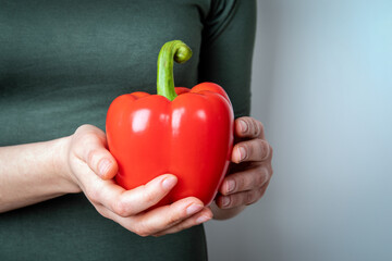Woman holding red, sweet pepper or paprika. Health and healthy lifesyle concept