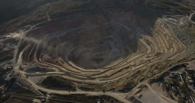 Industrial of opencast mining quarry with a lots of machinery at work on sea rocky coast. Extraction of gold, copper. Aerial drone wide shot at summer sunny sunset