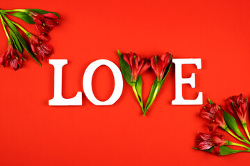 White letters love on a red background with alstroemeria flowers