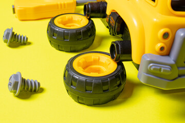 The toy typewriter is a concrete mixer and screwdriver that twists the cog on a yellow background....