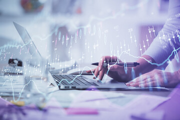 Double exposure of woman hands typing on computer and forex chart hologram drawing. Stock market...