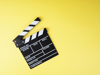 Fototapeta na wymiar the concept of the film industry, a minimalistic composition on a yellow background with glasses and clapperboard. movies and cinema.