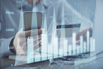 Double exposure of man hands holding a credit card and Forex graph drawing. Stock trading and digital fintech in Internet E-commerce concept.