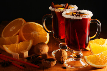 Two cups with ready mulled wine with anise, cinnamon and nuts around	