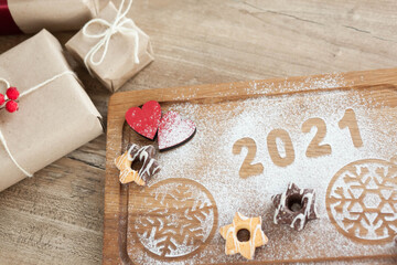 Christmas and New Year 2021 background with a festive plate with the inscription 2021 and boxes of gifts

