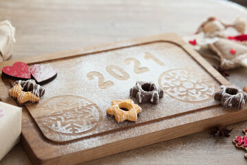 Christmas and New Year 2021 background with a festive plate with the inscription 2021 and boxes of gifts

