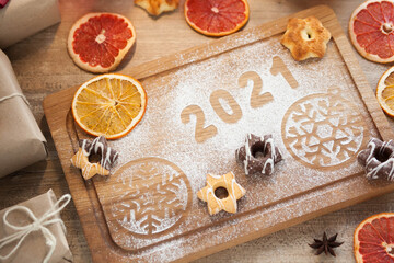 Christmas and New Year 2021 background with ingredients for cooking christmas baking decorated with fir tree. New Year's decor, homemade cookies preparing for the holiday.