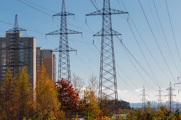 Overhead power lines against the multi-story buildings and sky