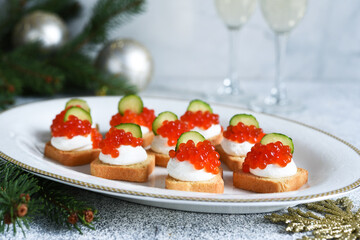 Toasts with cheese and red caviar on a New Year's table with champagne. New Year's table. Snack.