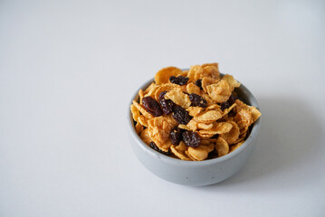 Homemade cornflakes caramel in a bowl. Cornflakes mixed with honey, caramel sauce, cashew nut and currant.