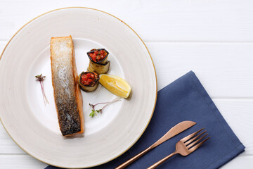 Roasted salmon fillet in plate on white wooden table