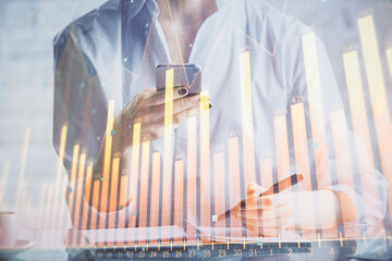 Double exposure of forex chart sketch hologram and woman holding and using a mobile device. Financial market concept.