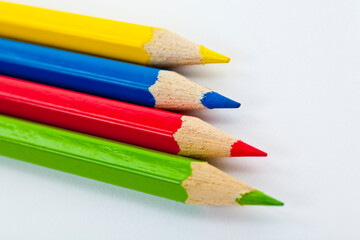 Four pencils, green, yellow, blue and red. Studio photo isolated on white background.