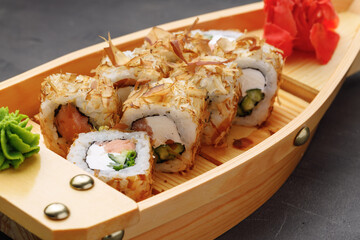 Sushi roll with tuna shavings on plate close up