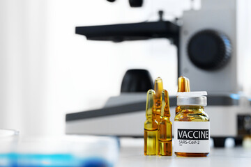 Vaccine in vial for injection on table against background of laboratory