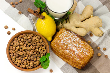 Chufa or tiger nuts in wooden bowl, tigernut milk in a glass, lemon and ginger on tablecloth. Healthy, organic food concept