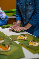 Wrapping tamales Latin American dish.