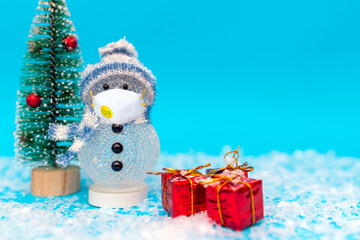 snowman with protective mask presents and Christmas tree snow with copy space.new year celebration.