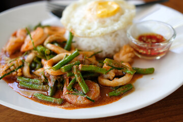 shrimp squid stir fried with cow pea & spicy sauce serving with rice & fried egg