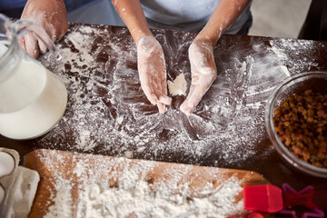 Person hands putting flour on kitchen table surface