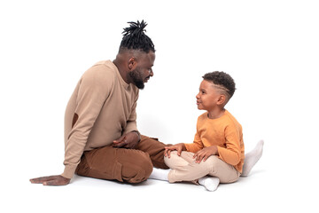 Dark skinned African male and his little son spending time together, isolated